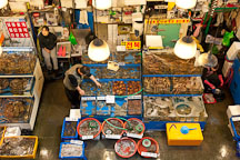 A vendor at the Noryangjin Fish Market in Seoul checks on his wares. - Photo #21188