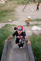 Boy climbing up slide (concrete drain). Thimphu, Bhutan. - Photo #22390