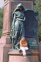 Girl sitting at the statue of the Patron muse of Finnish poetry. Runebergin esplanadi, Helsinki, Finland. - Photo #395