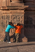 Two boys playing hide and go seek. The Cathedral, Plaza de Armas, Cusco, Peru. - Photo #9296
