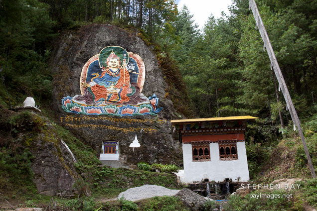 Guru Rinpoche painted on a rock wall. Road from Thimphu to Punakha, Bhutan.