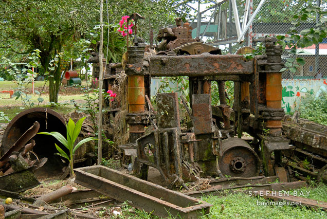 Vegetation grows over abandoned machinery in Tortuguero Village, Costa Rica.
