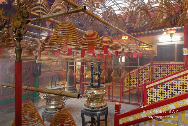 Incense coils hang from poles stretched across the temple. Man Mo Temple, Hong Kong, China.