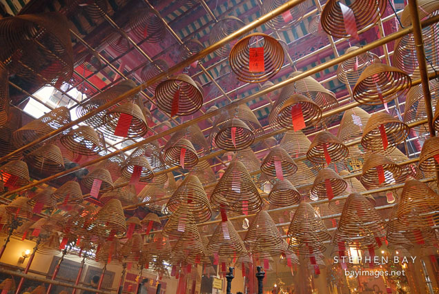 The ceiling of the Man Mo Temple is covered with hanging incense coils. Hong Kong, China.