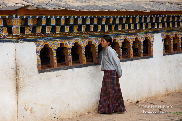 Young girl spinning prayer wheels at Chimi Lhakhang. Lobesa valley, Bhutan.