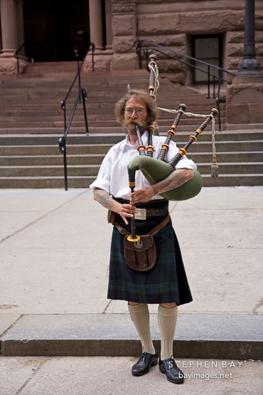 Man playing bagpipes on the steps of Old City Hall. Toronto, Canada.