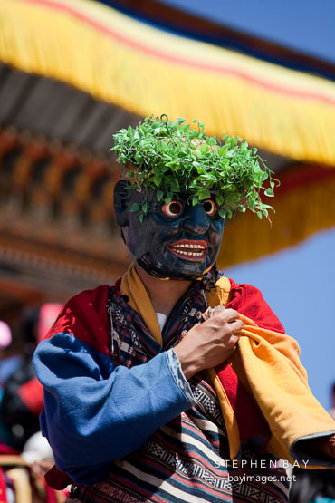 Atsara (clown) collecting donations from the crowd. Thimphu tsechu, Bhutan.