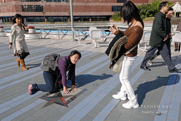 Young women having fun at the Avenue of Stars. Tsim Sha Tsui, Kowloon, Hong Kong, China.