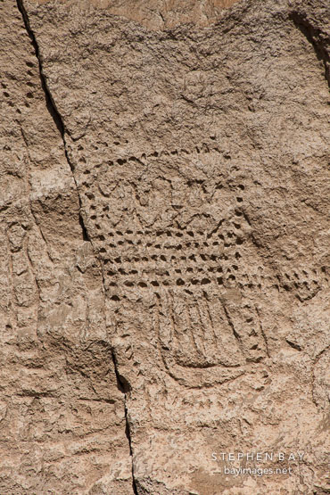 Petroglyphs carved into rock wall. Petroglyph Point, California.