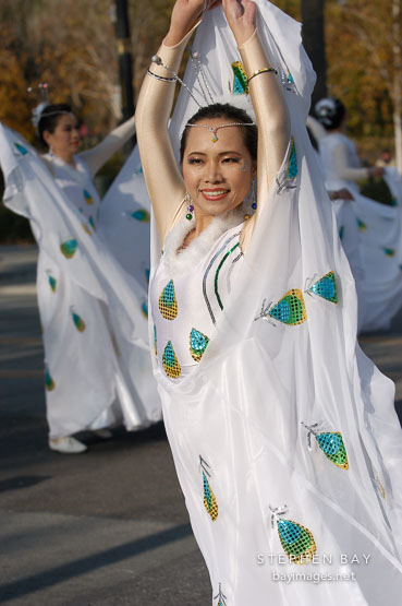 Asian woman in white dress. San Jose Holiday Parade. San Jose, California, USA.
