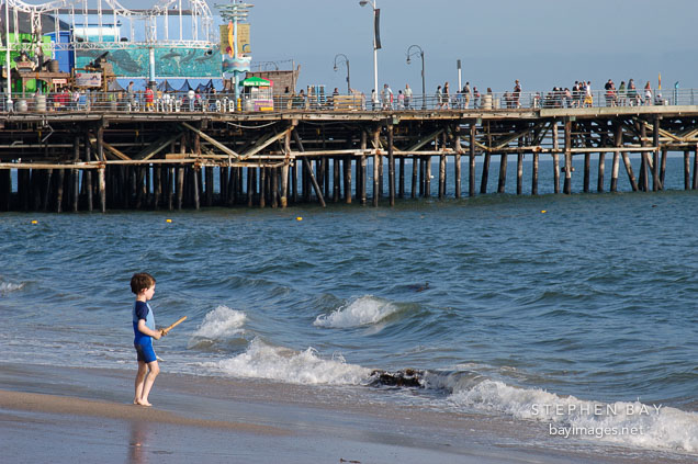 Boy at the watching the waves. Santa Monica beach, California, USA.