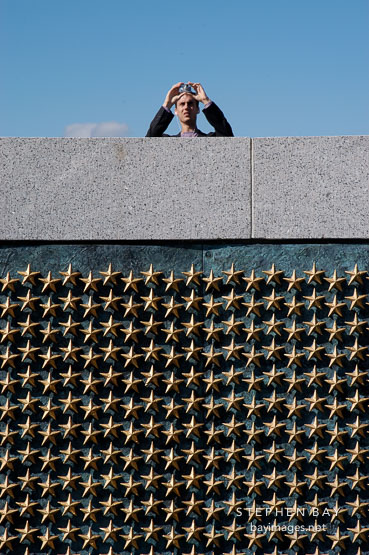 Tourist photographing the National World War II Memorial. Washington, D.C., USA.
