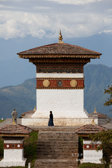 Woman walking around the main chorten at Dochu La pass, Bhutan.