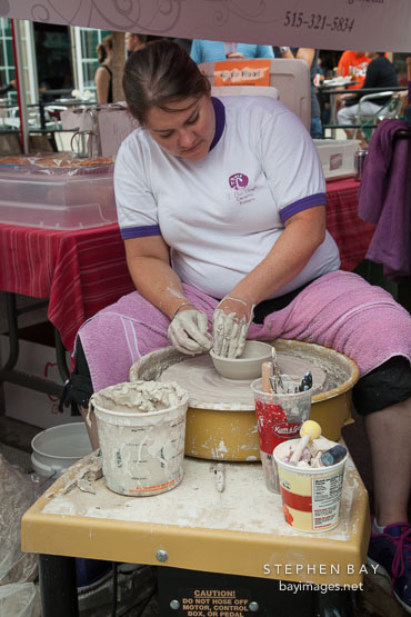 Woman making pottery at the Des Moines farmer's market.