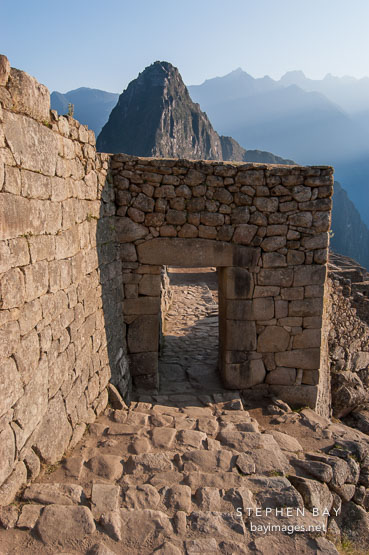 Entrance gate to Machu Picchu and Huayna Picchu (background). Machu Picchu, Peru.