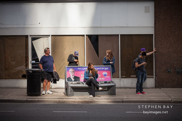People waiting for the bus on King Street. Hamilton, Canada.