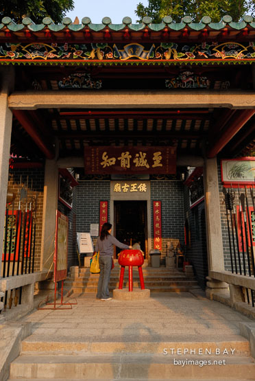 Woman placing incense. Hau Wong Temple. New Kowloon, Hong Kong, China.