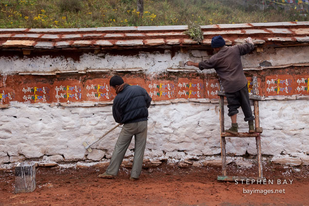 Workers painting mani wall at Dochu La pass, Bhutan.