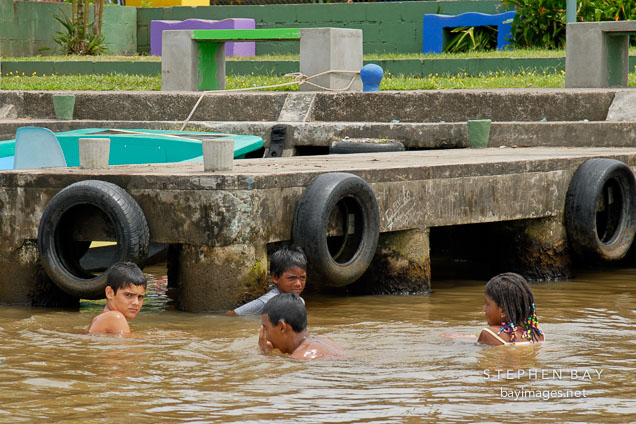 Children swimming and playing in the water. Tortuguero village, Costa Rica.