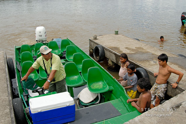 Children investigating a tourist boat. Tortuguero village, Costa Rica.