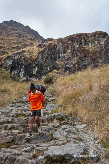 Porter walking down steps on the Inca trail. Peru.