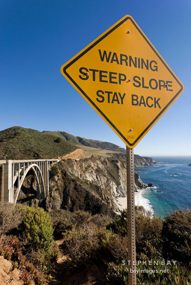 Warning, steep slope, stay back. Sign near Bixby Bridge, Big Sur, California, USA.