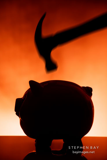 Hammer about to smash a piggy bank.