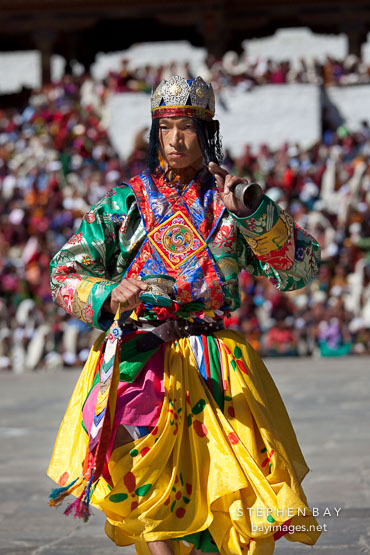 Dancer with golden crown and yellow skirt. Thimphu tsechu, Bhutan.