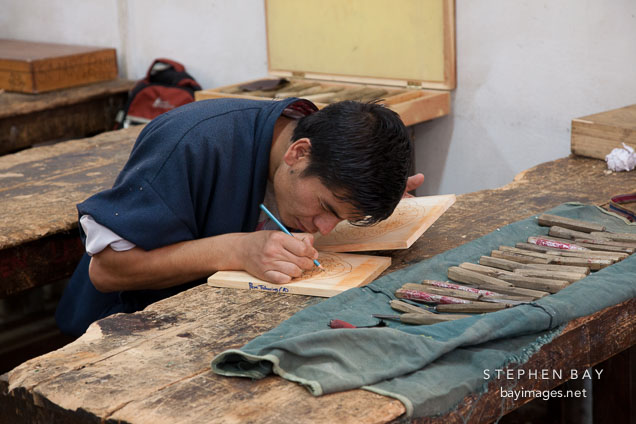 Student drawing design on wood block before carving. National Institute for Zorig Chusum, Thimphu, Bhutan.