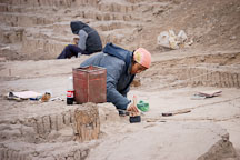 Woman brushing dirt during an excavation at Huaca Pucllana, an adobe pyramid. Lima, Peru. - Photo #8744