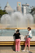 Two women chatting by the fountain. Hong Kong Park, China. - Photo #16454