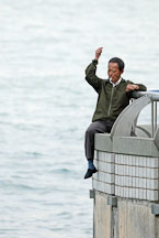 Man sitting on railing near the Hong Kong Convention Center fishing. Hong Kong, China. - Photo #15290